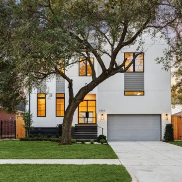 Dusk photo of 3855 Gramercy St, a white modern two-story home in Braes Heights, Houston, built by Scale Design+Build