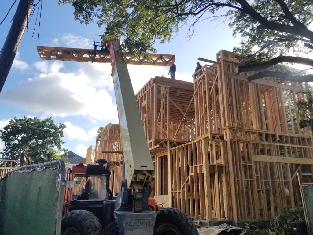 Setting a roof truss on a Scale Design+Build job site during framing